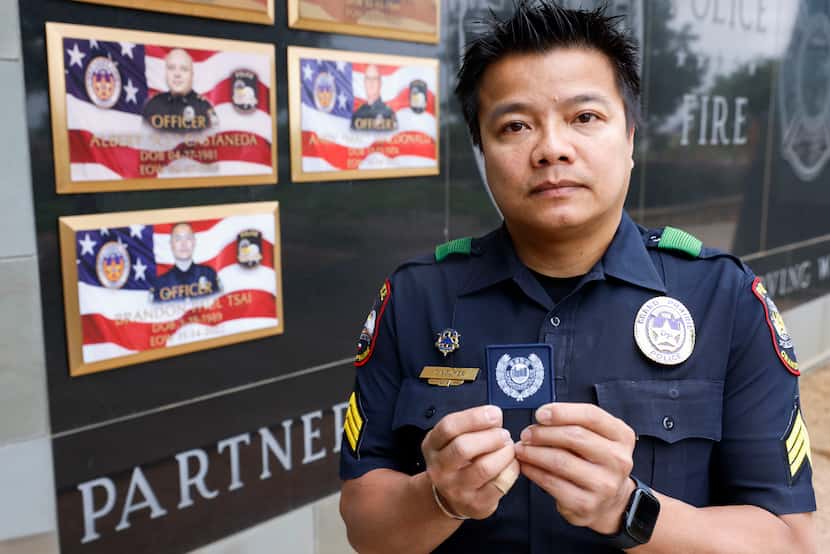 Grand Prairie Police Sgt. Thai Nguyen, poses for a portrait holding a Hong Kong patch he got...