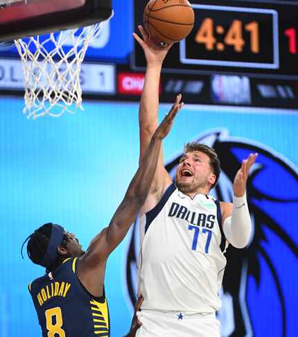 Orlando, FL - JULY 26: Luka Doncic #77 of the Dallas Mavericks shoots the ball against the...