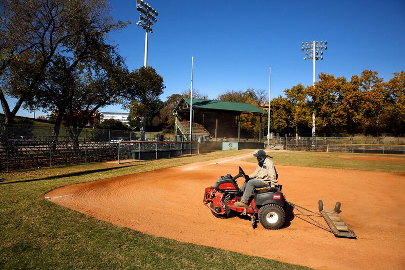 Lawrence Willie of the Dallas Park and Recreation Department rakes the Reverchon ballpark...