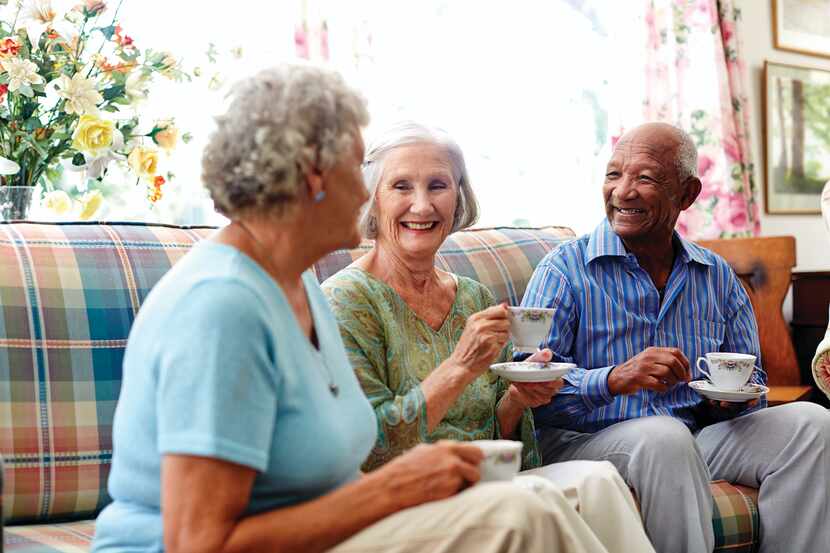 Happy senior people having coffee in nursing home.