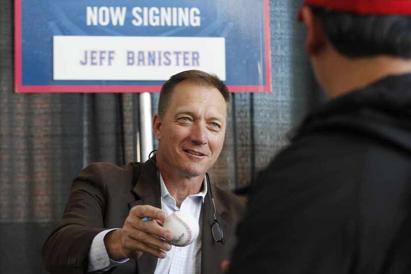 Texas Rangers manager Jeff Banister, gives an autographed ball to a fan during the 2015...