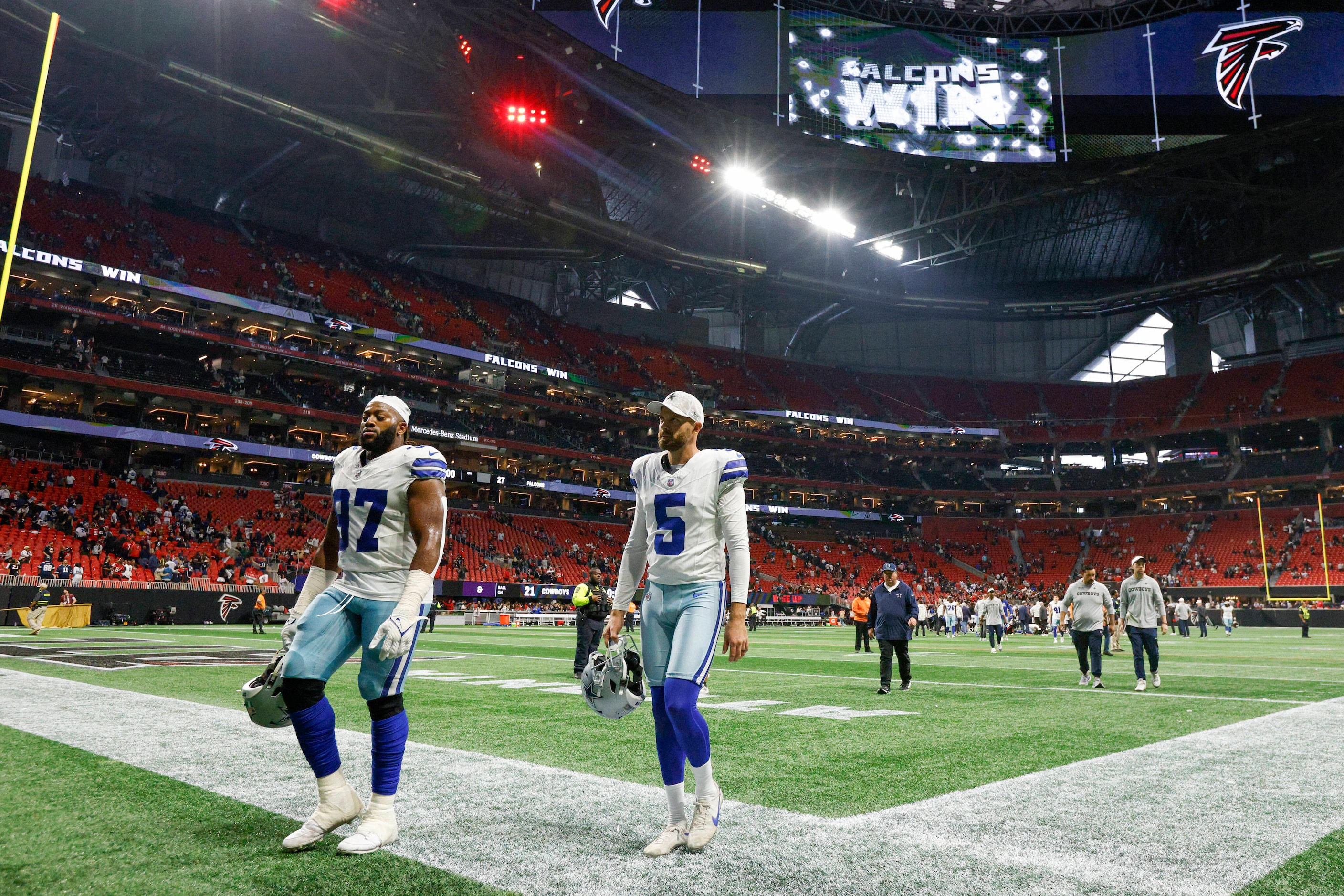 Dallas Cowboys defensive tackle Osa Odighizuwa (97) and punter Bryan Anger (5) walk of the...