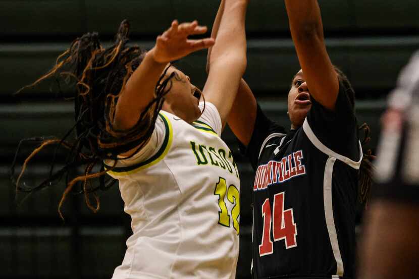 Duncanville's Kaila Kelley (14) attempts a shot as DeSoto's Jiya Perry (12) tries to block...