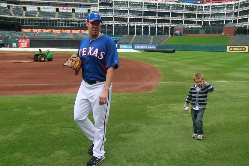 Colby Lewis is followed by his son, Cade, after the two played catch before Game 2 of 2011...