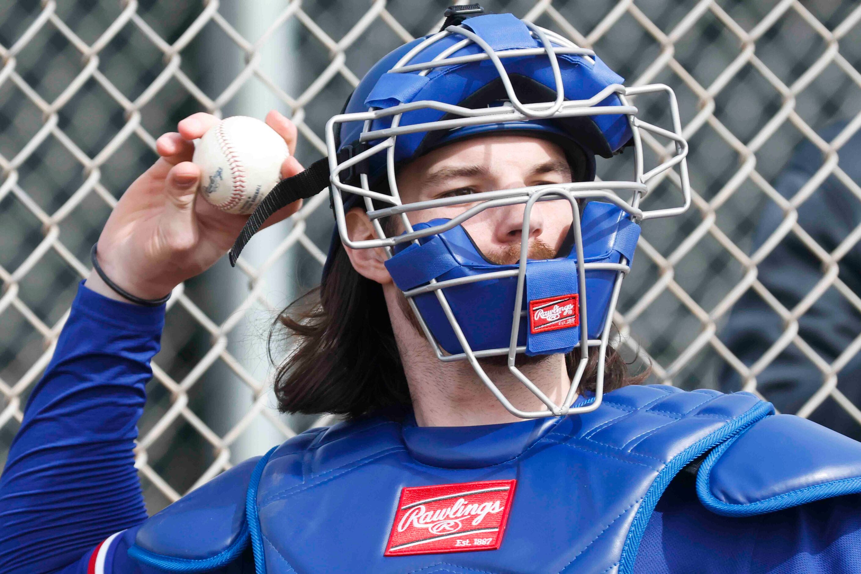 Texas Rangers catcher Jonah Heim throws back to the pitcher during spring training workout...