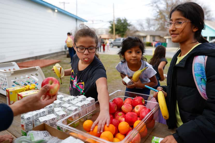 La Tiendita founder Jason Hernandez (not in the photo) offers elementary students Mila...