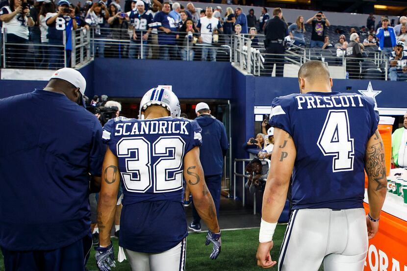 Dallas Cowboys quarterback Dak Prescott (4) and cornerback Orlando Scandrick (32) left the...