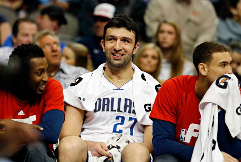 Dallas Mavericks center Zaza Pachulia (center) is all smiles on the bench after his...