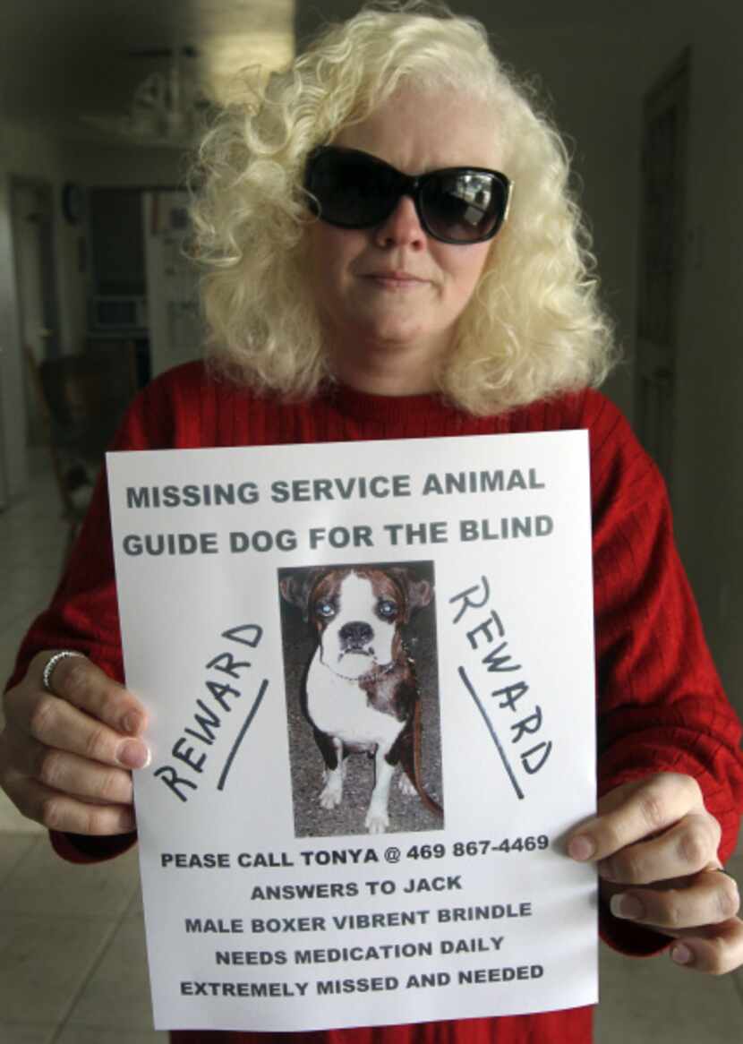Tonya Gaskill poses with a poster for her lost dog at her home in Carrollton.
