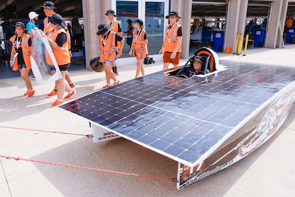 Grace Kiowski of Greenville High School, Tex., is towed in her team's solar car as they...