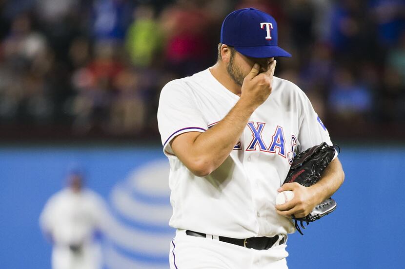 Texas Rangers relief pitcher Shawn Tolleson reacts after giving up a single to pinch hitter...