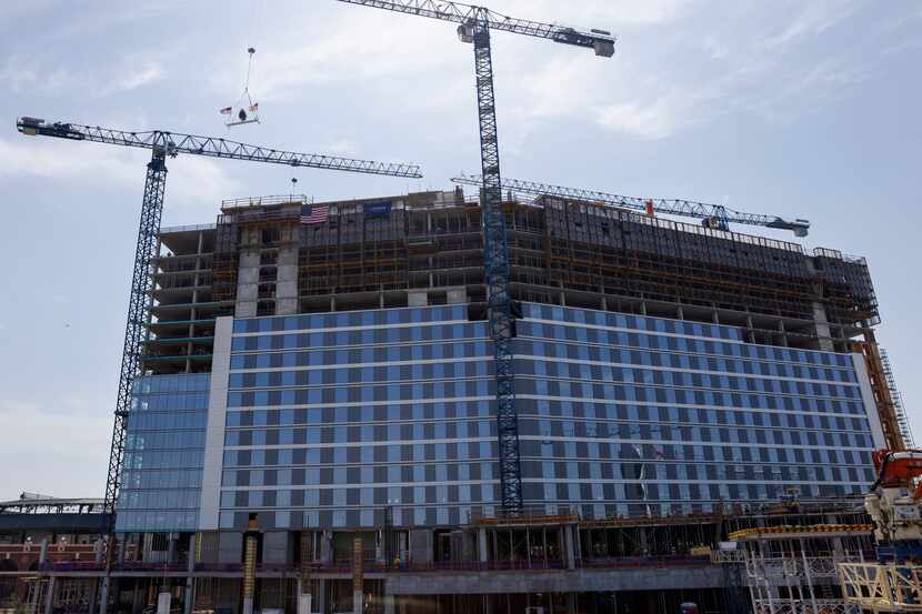 A crane hoists a beam towards the Loews Arlington Hotel during a topping out ceremony in...
