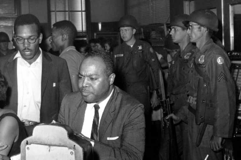 James Farmer, director of the Congress of Racial Equality, sits at a previously white lunch...