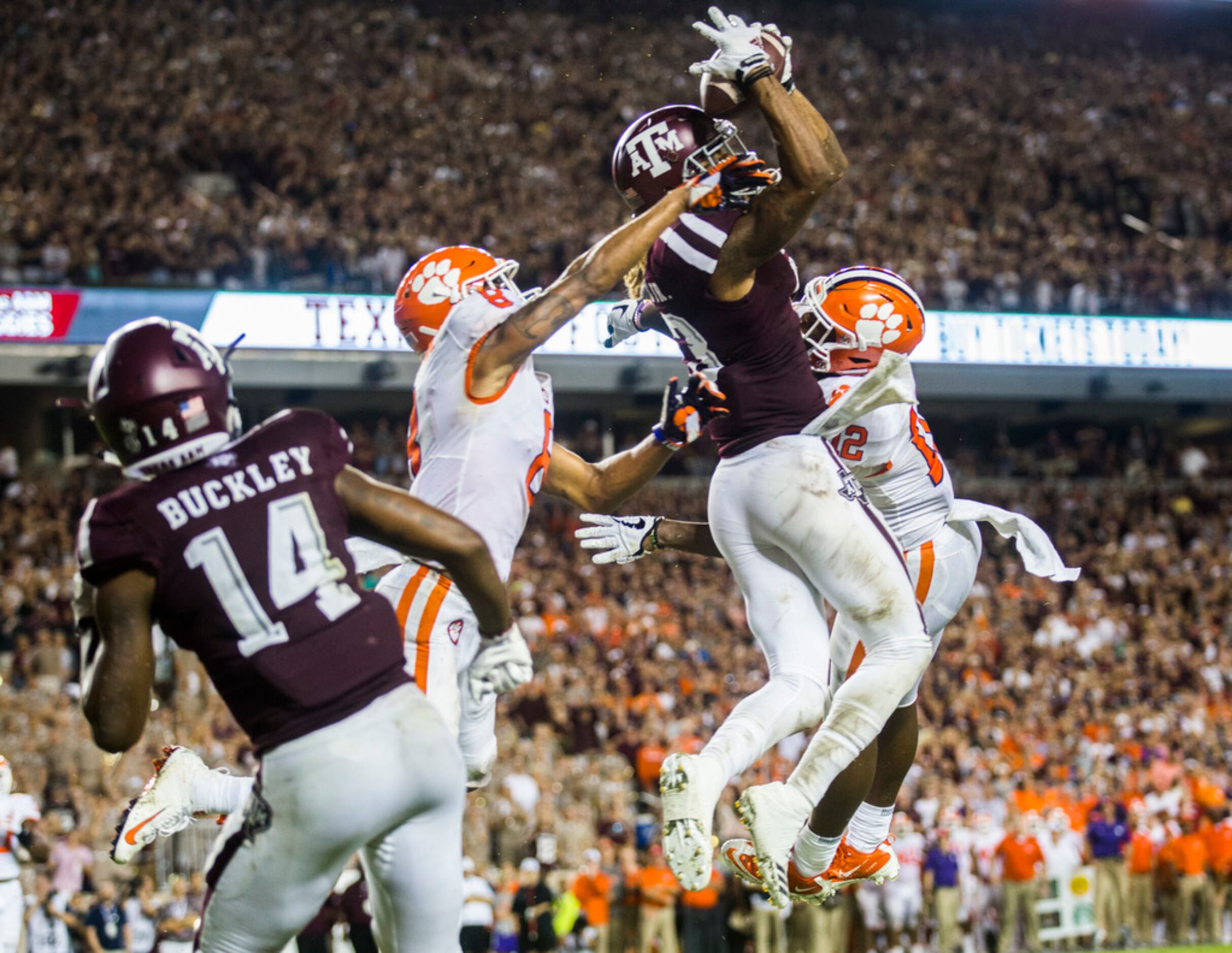 Texas A&M's Kendrick Rogers, top, is tackled by Clemson's Derion