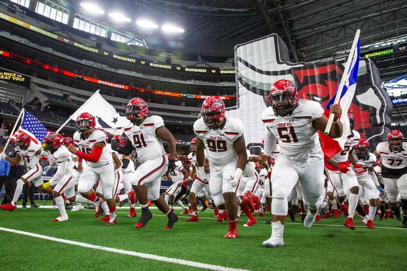 The Cedar Hill varsity team rushes onto the field before the Class 6A Division II area-round...