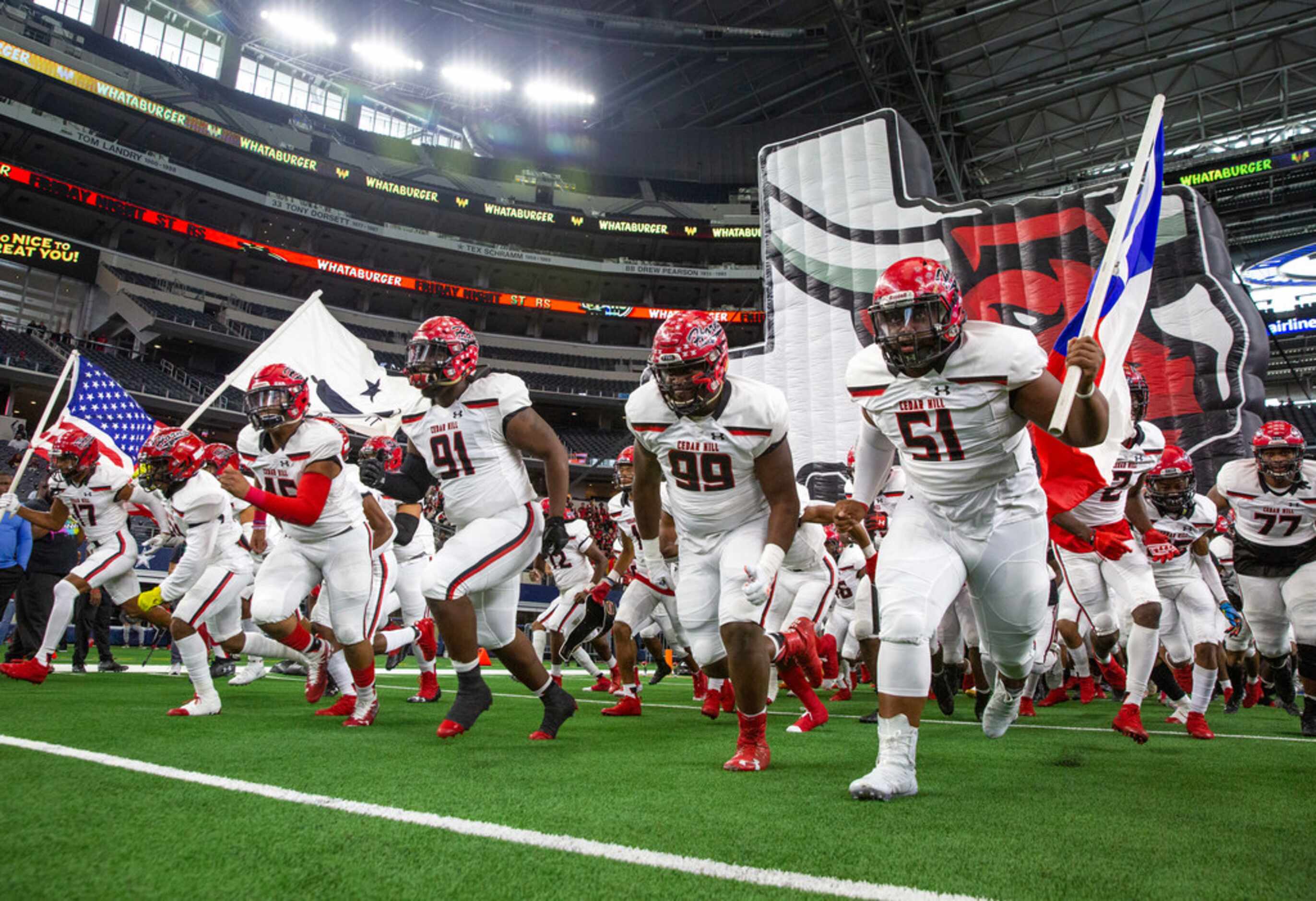 The Cedar Hill varsity team rushes onto the field before the Class 6A Division II area-round...