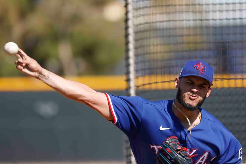 Texas Rangers pitcher Jonathan Hernández throws a pitch for batting practice during a spring...