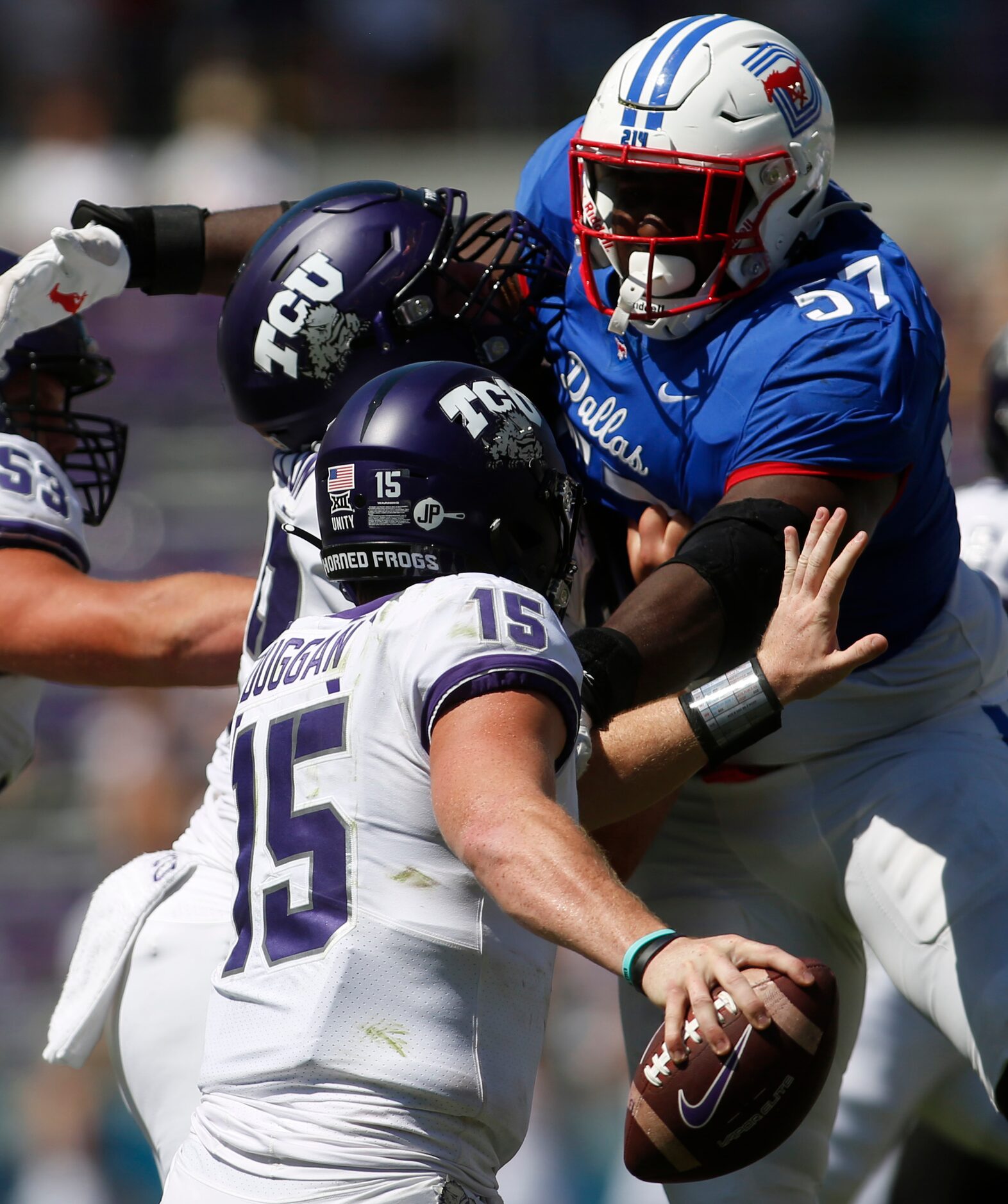 SMU defensive tackle Mike Williams (57) looms large as TCU quarterback Max Duggan (15)...