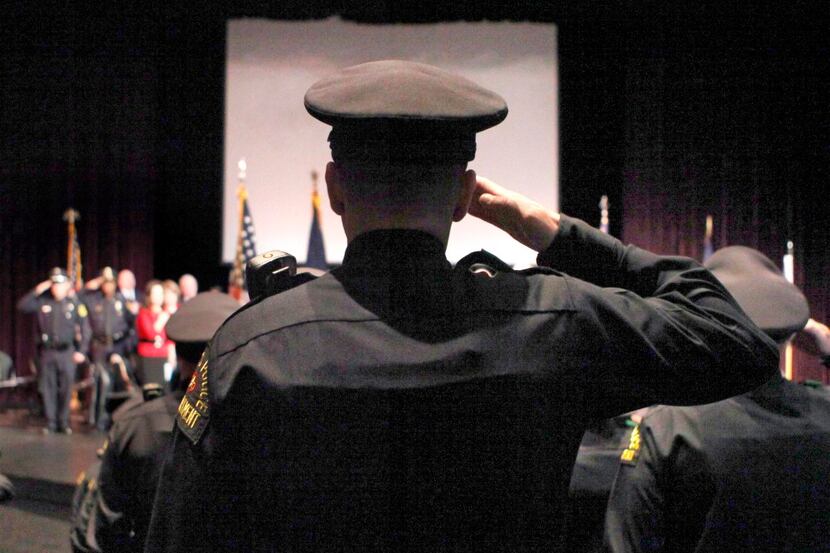 
Graduates salute during a ceremony for a Dallas Police Department Basic Academy recruit...