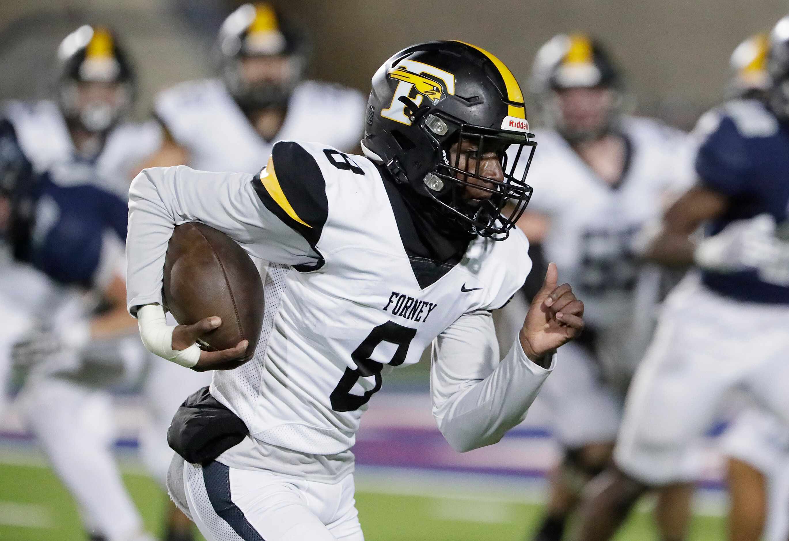 Forney High School place holder for an extra point attempt Alijah Merkson (8) sprints for...