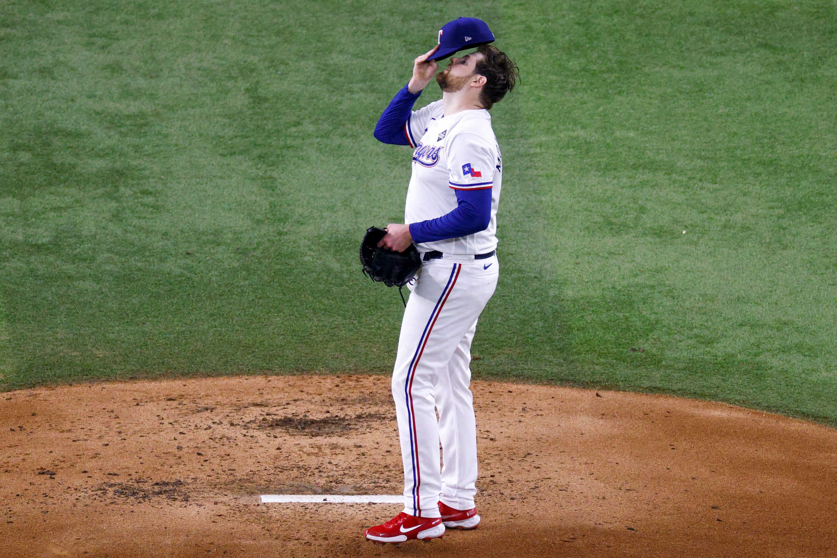 Texas Rangers starting pitcher Jordan Montgomery (52) reacts after giving up a home run to...