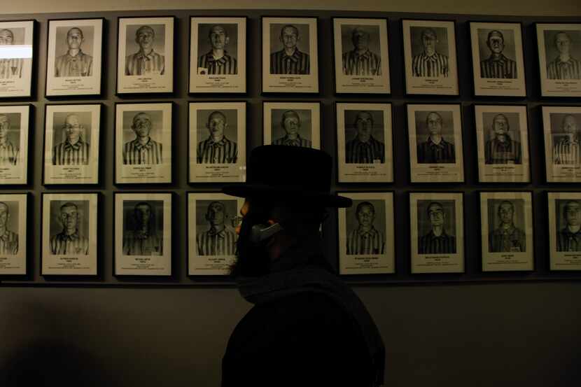 An orthodox Jew walks past the portraits of victims at the former Nazi German concentration...