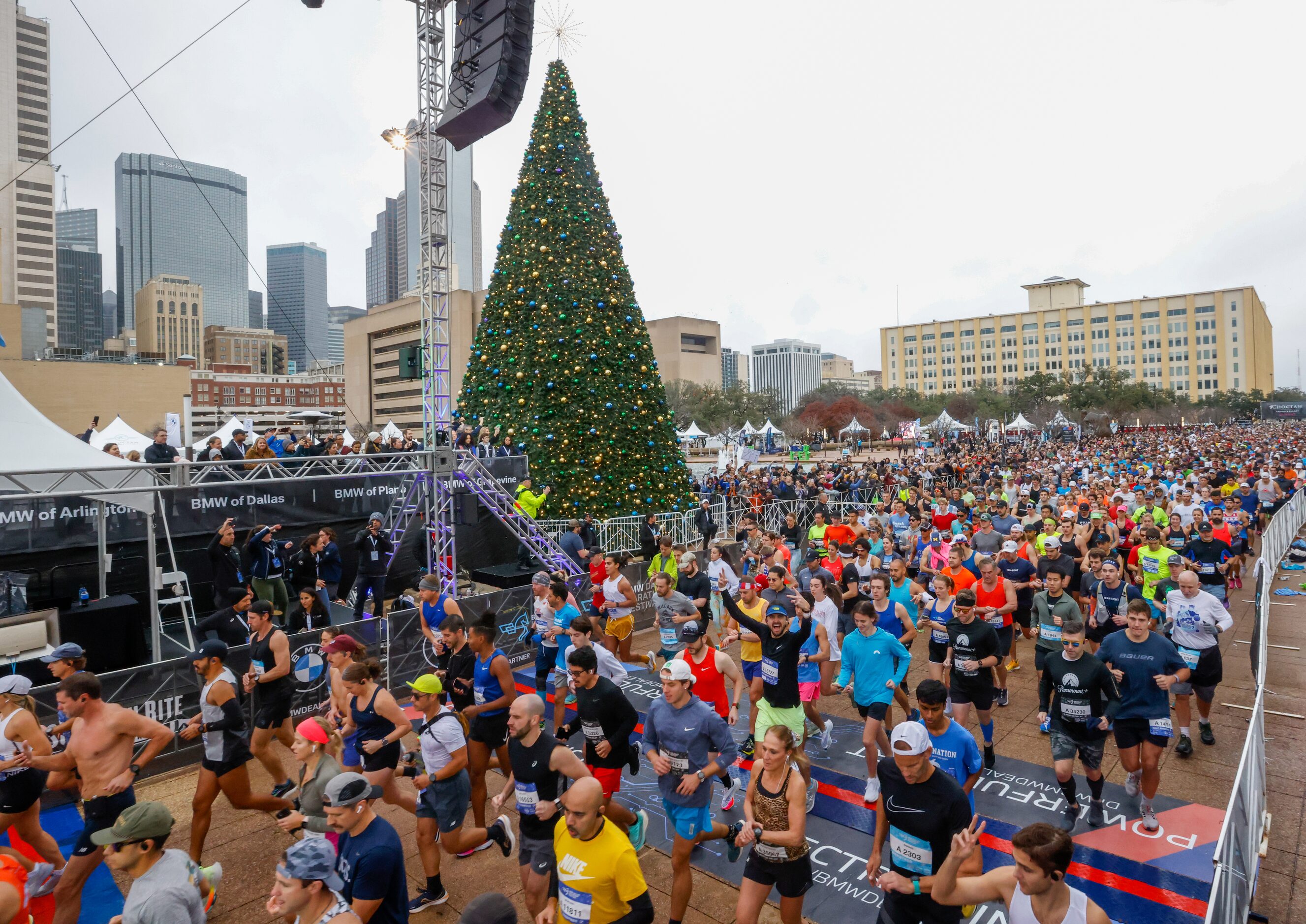 Runners cross the BMW Dallas Marathon start line in front of Dallas City Hall on Sunday,...