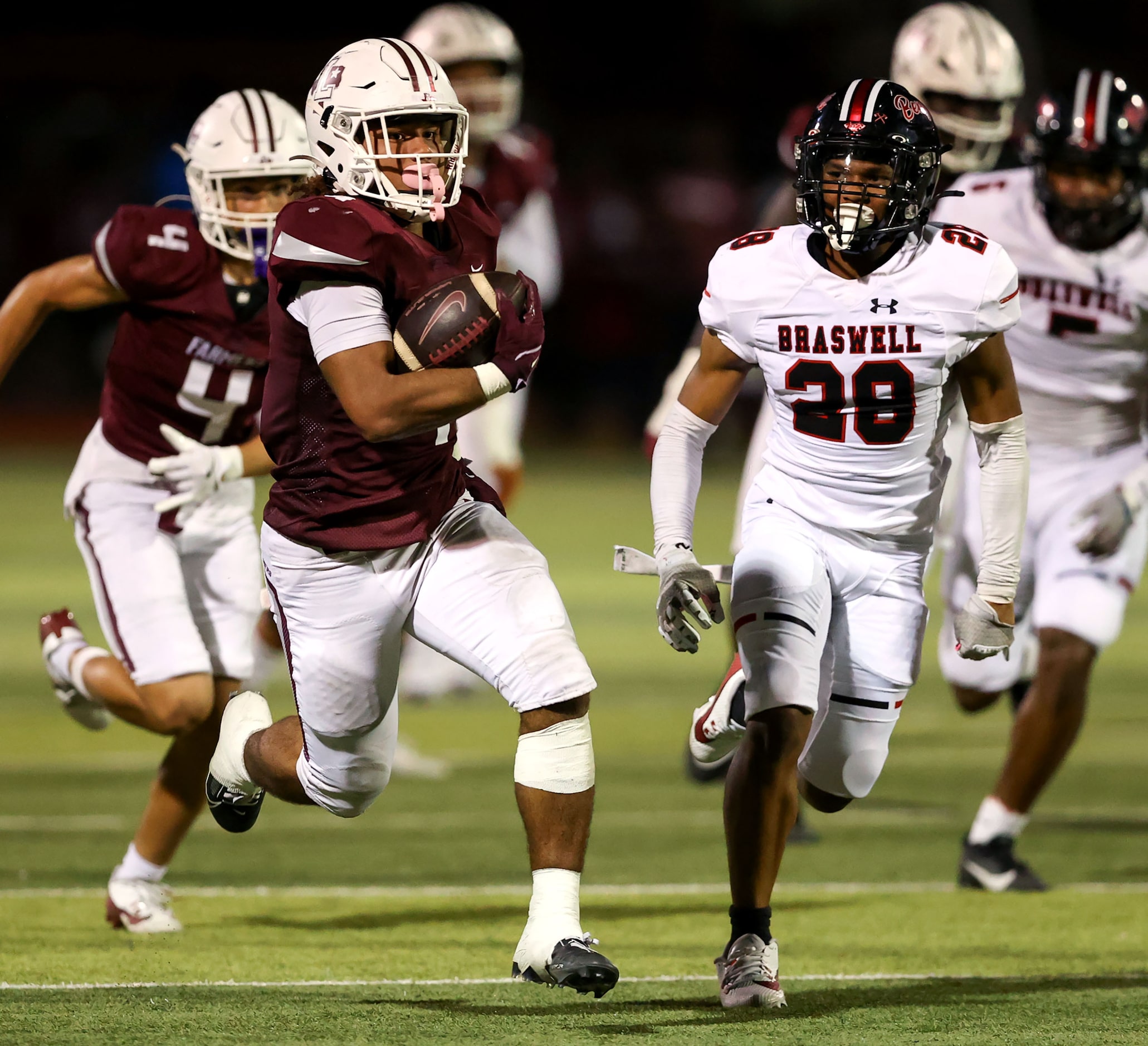 Lewisville running back Tenel Hill (9) runs past Denton Braswell safety Karson Perry (28)...