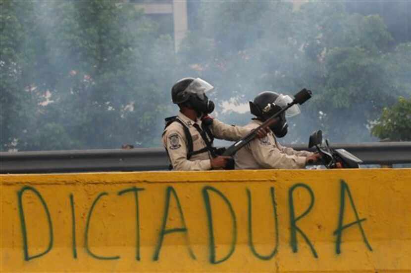 Agentes de policía enfrentan a opositores del gobierno durante una marcha en Caracas,...