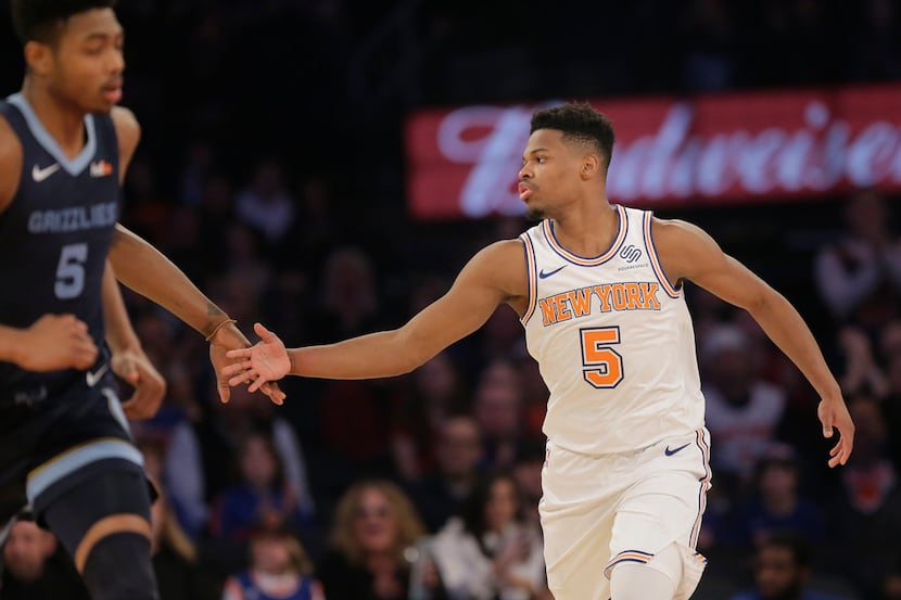 New York Knicks' Dennis Smith Jr., right, reacts after the Knicks scored during the first...