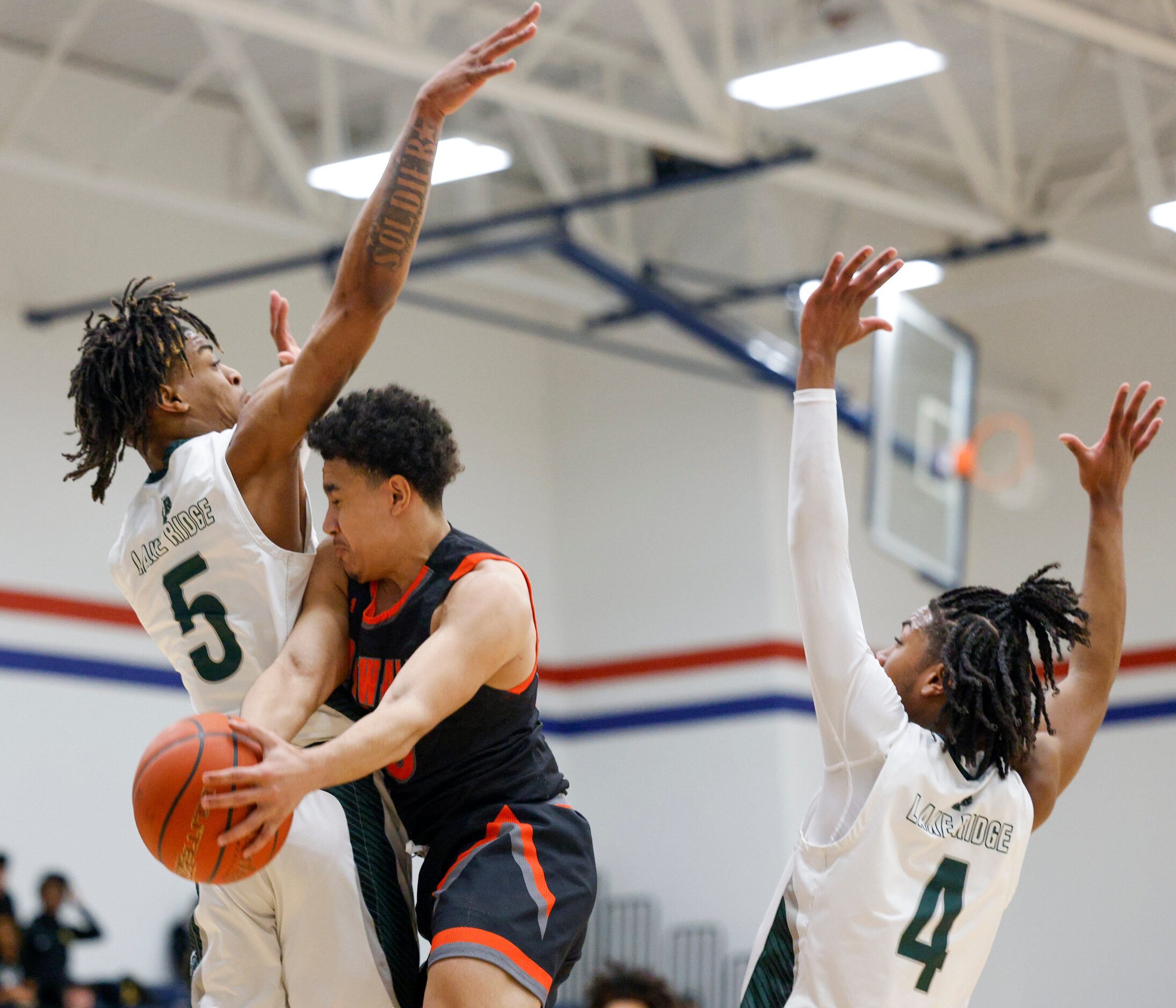 Rockwall's D'von Turner (00) passes the ball between Mansfield Lake Ridge's Ahmare Rose (5)...