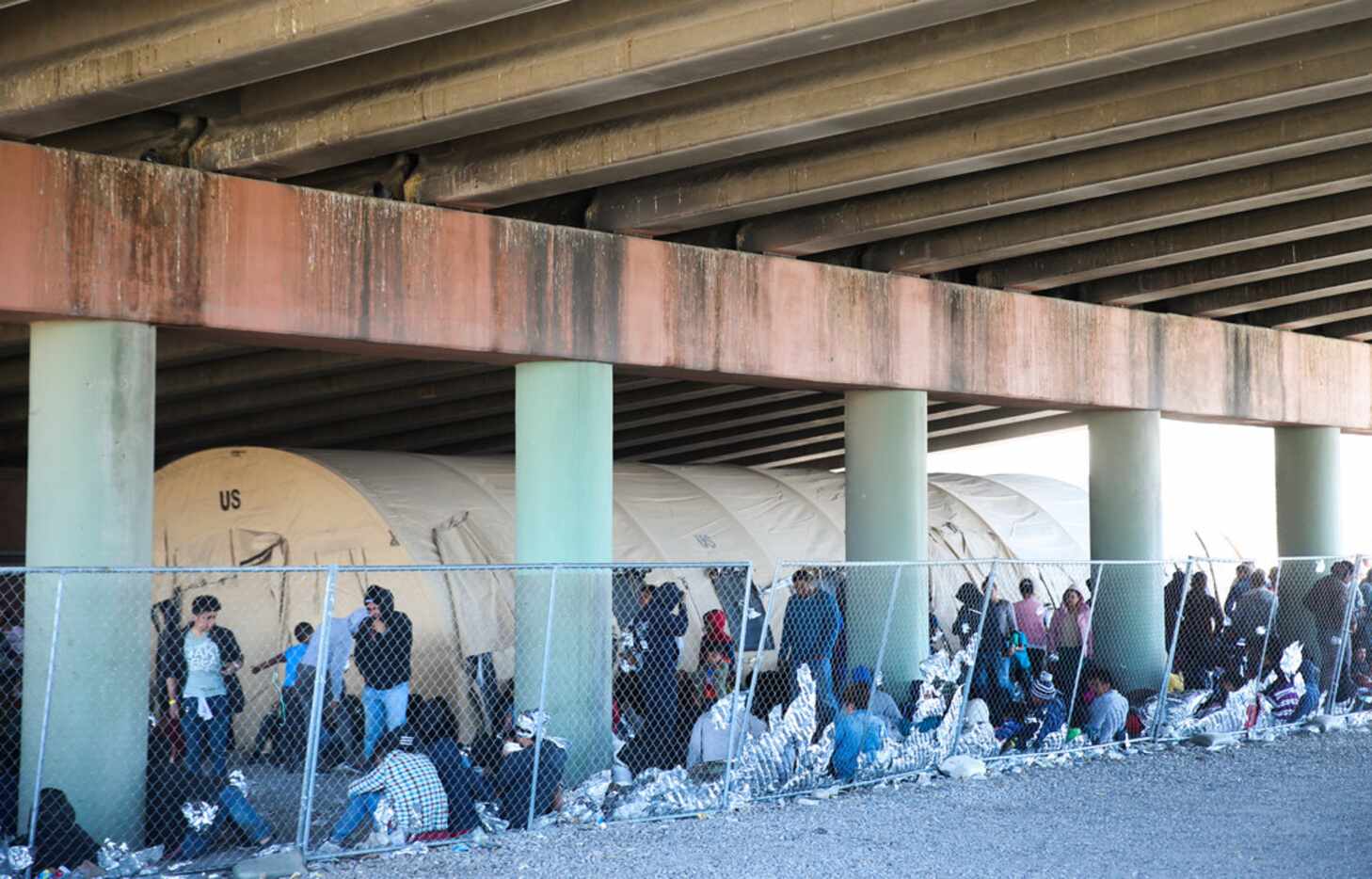Migrants seeking asylum are held in a temporary transition shelter under the Paso Del Norte...