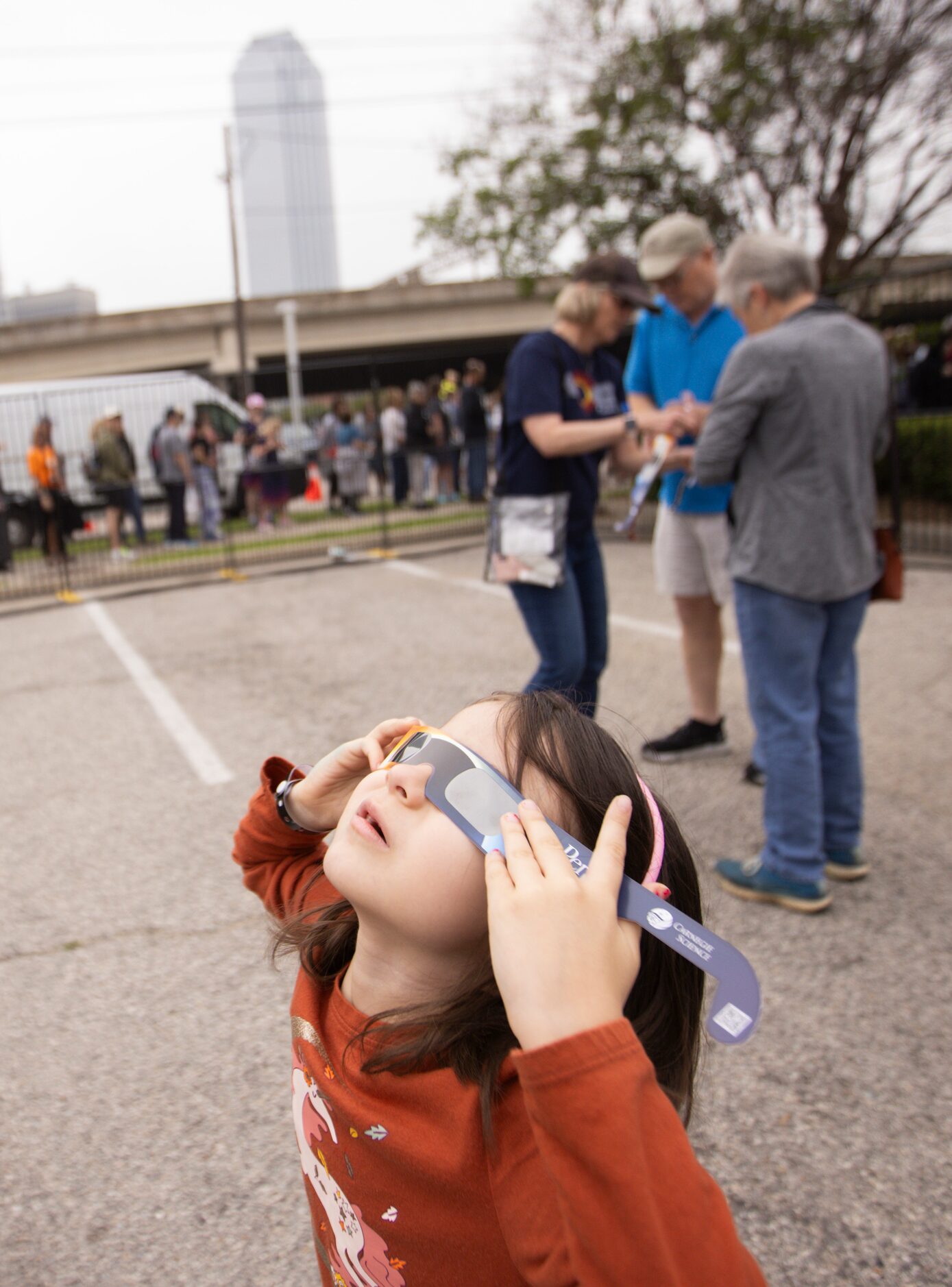 Adela Smith, 5, of Dallas tries on her eclipse glasses as she enters the Great North...