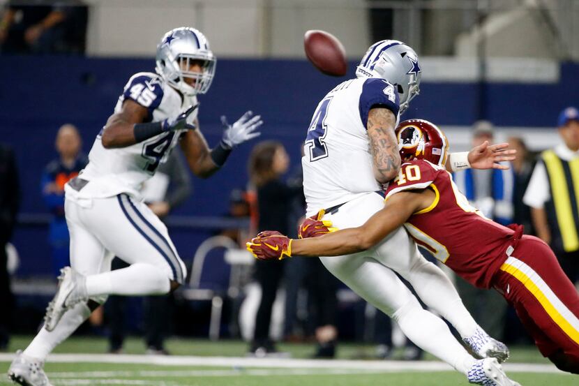 Dallas Cowboys quarterback Dak Prescott (4) gets hit by Washington Redskins linebacker Josh...