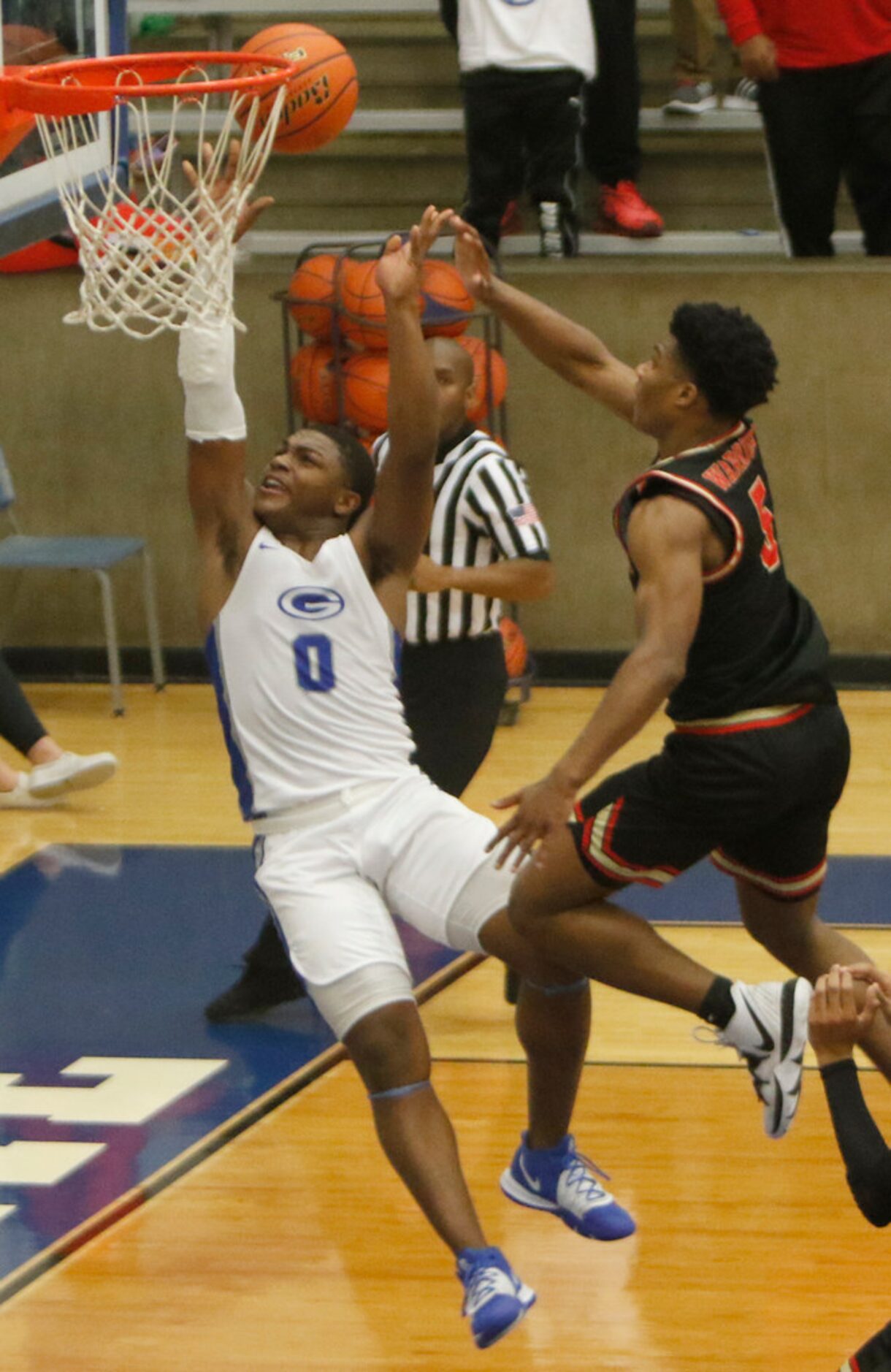 Grand Prairie's Savion Red (0) scores on a layup following a steal despite the defense of...