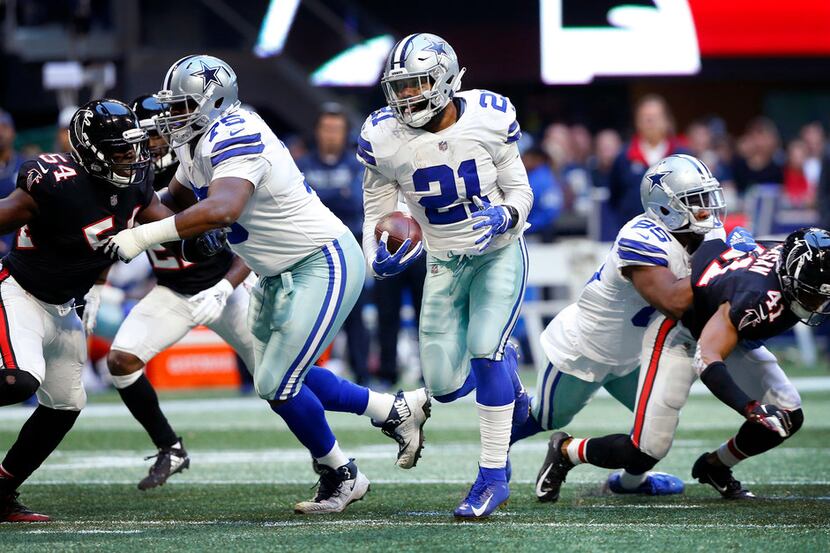 Dallas Cowboys running back Ezekiel Elliott (21) breaks through a hole in the Atlanta...