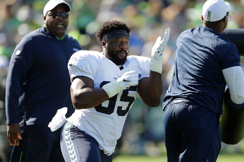 Seattle Seahawks rookie defensive end L.J. Collier works with coaches as he runs a drill,...