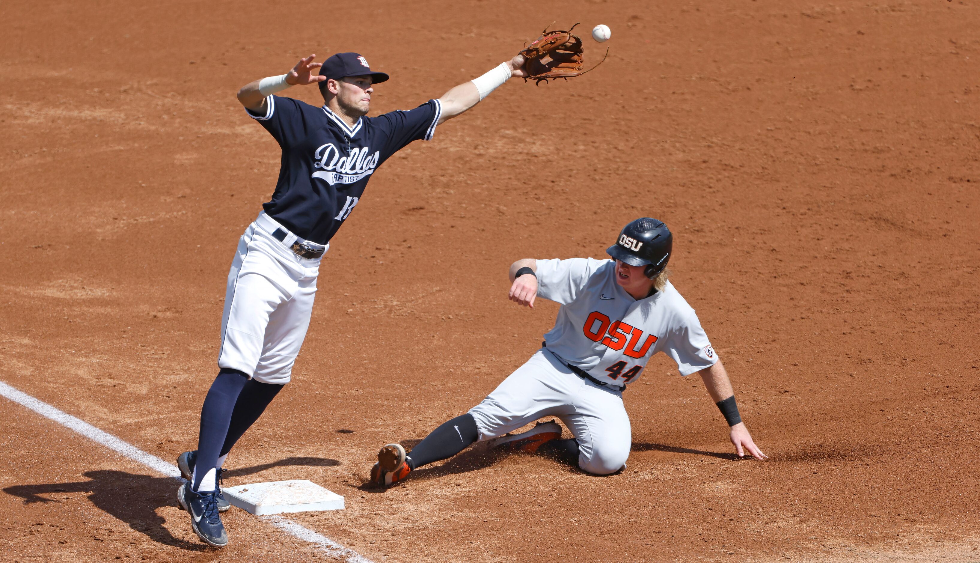 Dallas Baptist third baseman Andrew Benefield (13) canÕt field the high throw as Oregon...