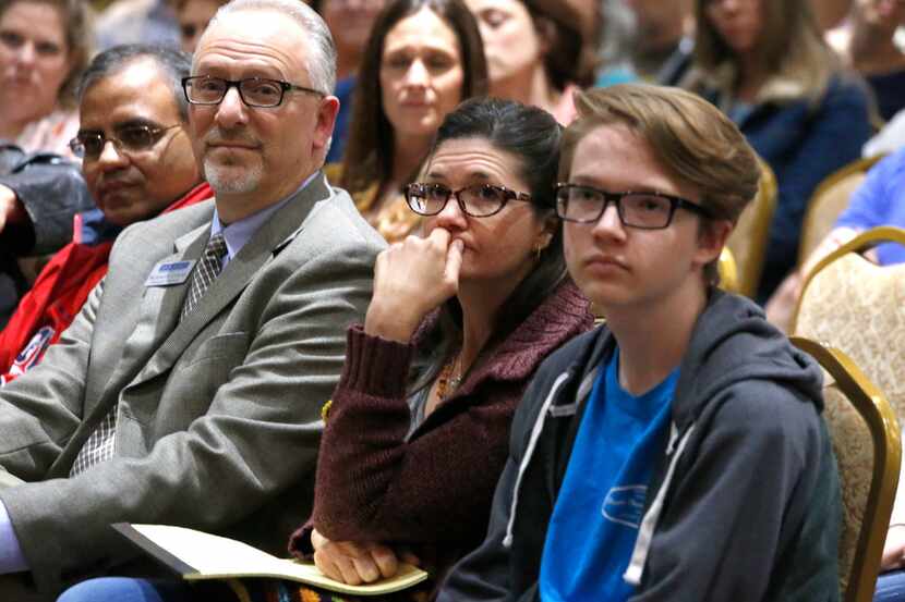 McKinney residents Kimberly Teeling (center) and her son Jimmy (right), 16, listen at a...