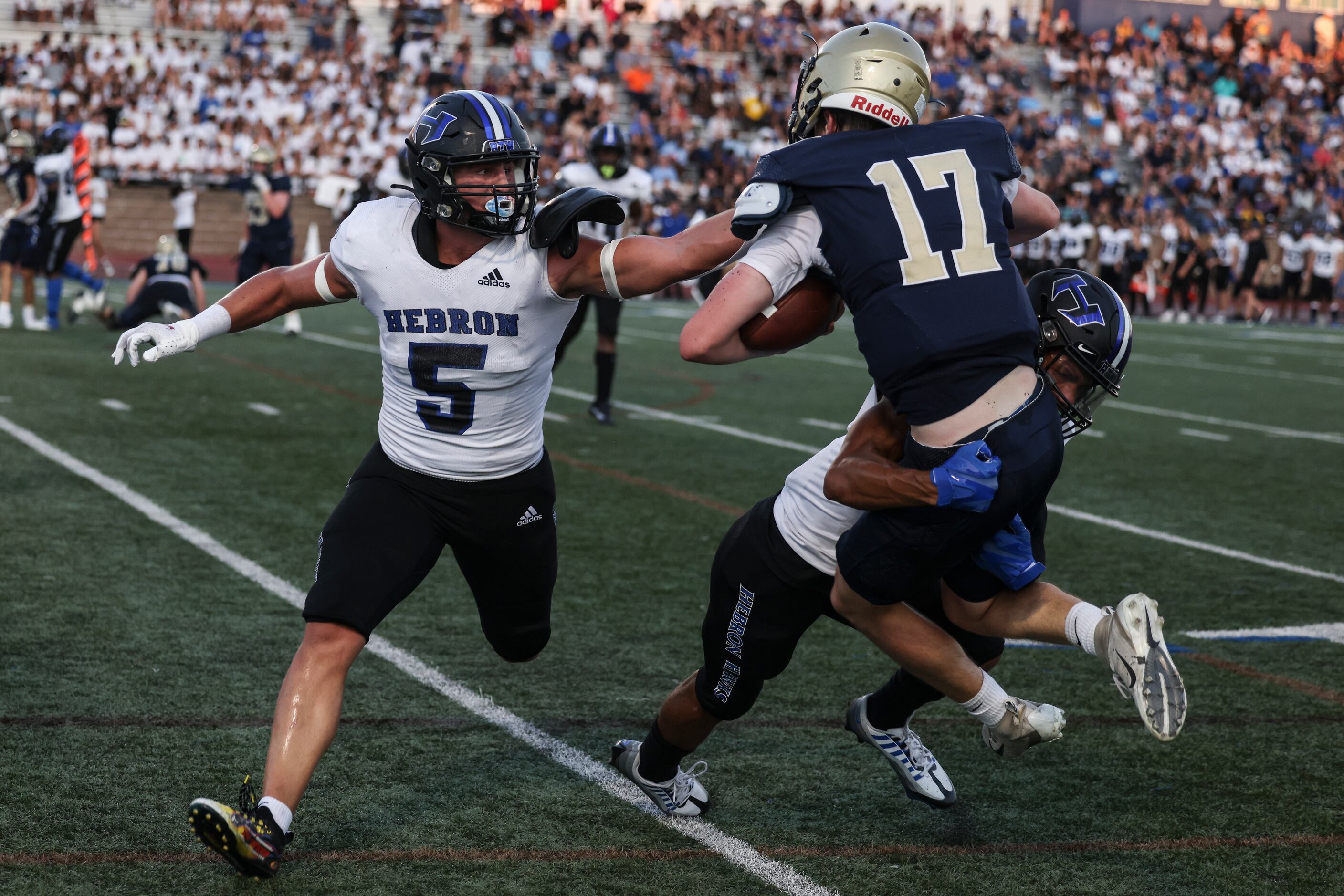 Hebron High School Carson Dean (5) defends as Tyler Slomka (9) tackles Jesuit Dallas Charlie...