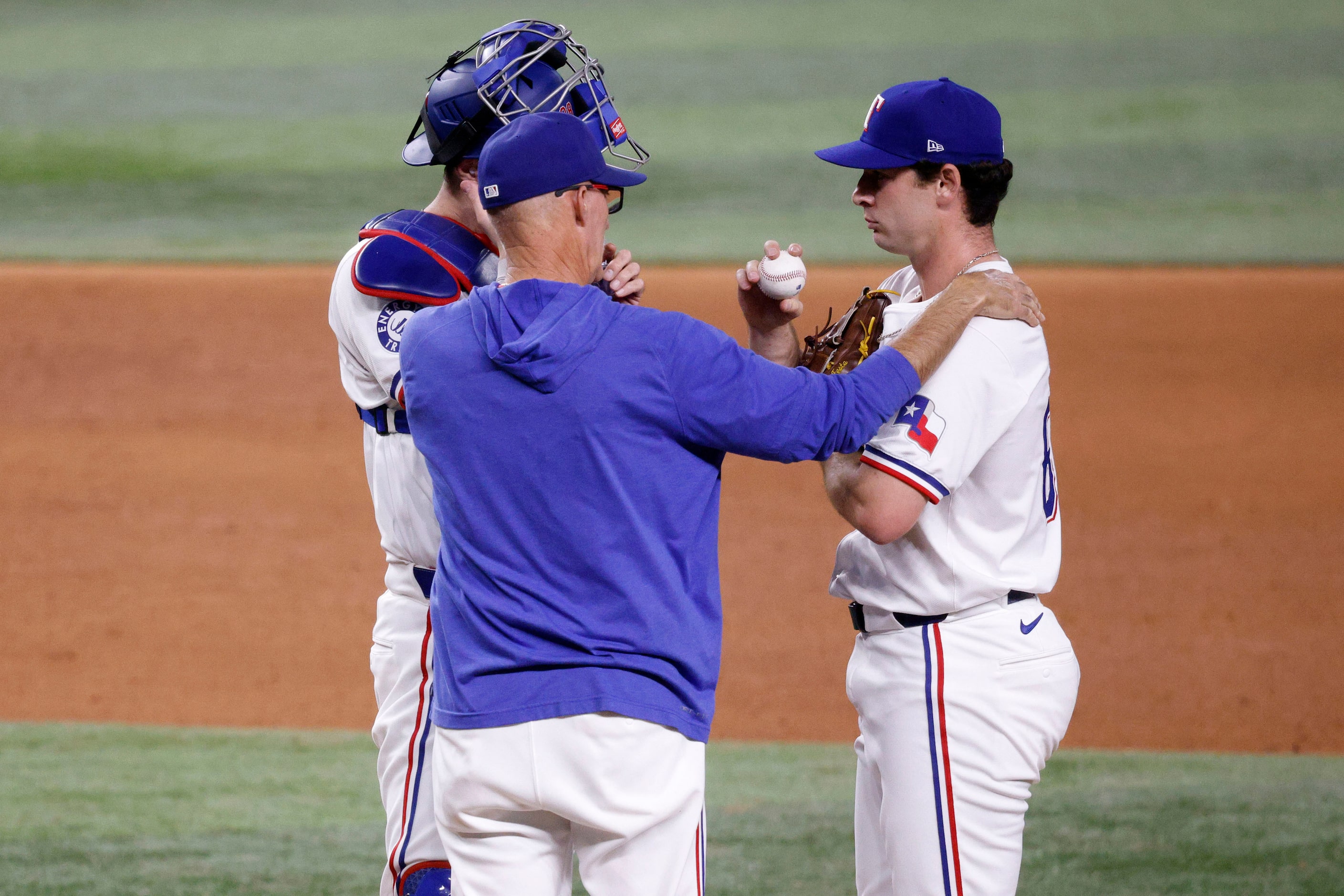 Texas Rangers pitching coach 
Mike Maddux, center, talks to Texas Rangers pitcher Matt Festa...