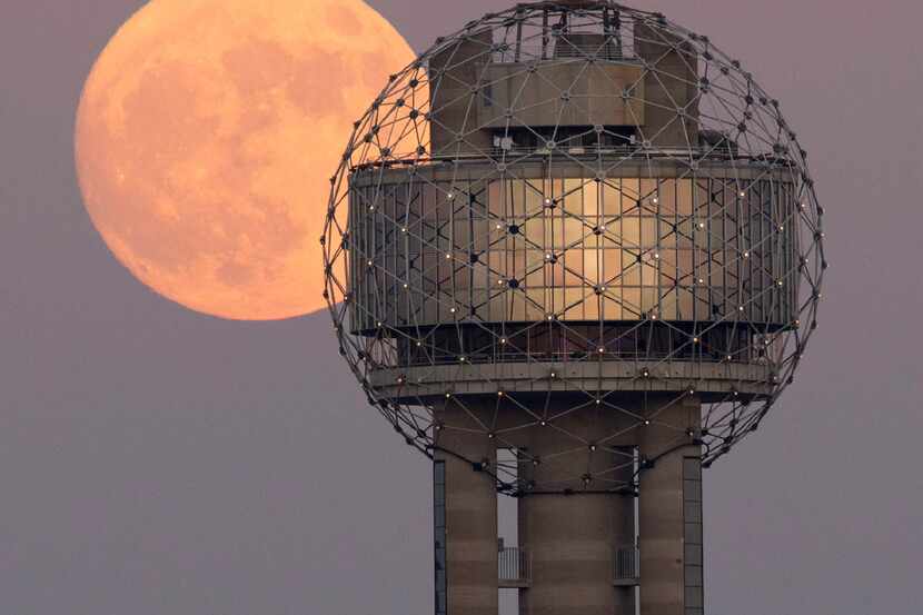 A supermoon rises over Reunion Tower in downtown Dallas.