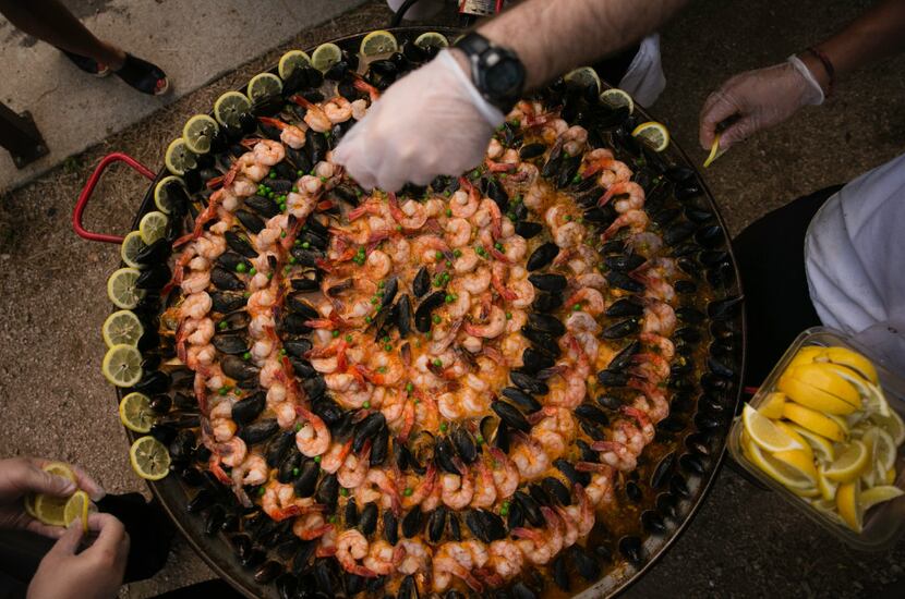 Chef Juan Rodriguez puts the final touches on the seafood paella during the supper club...