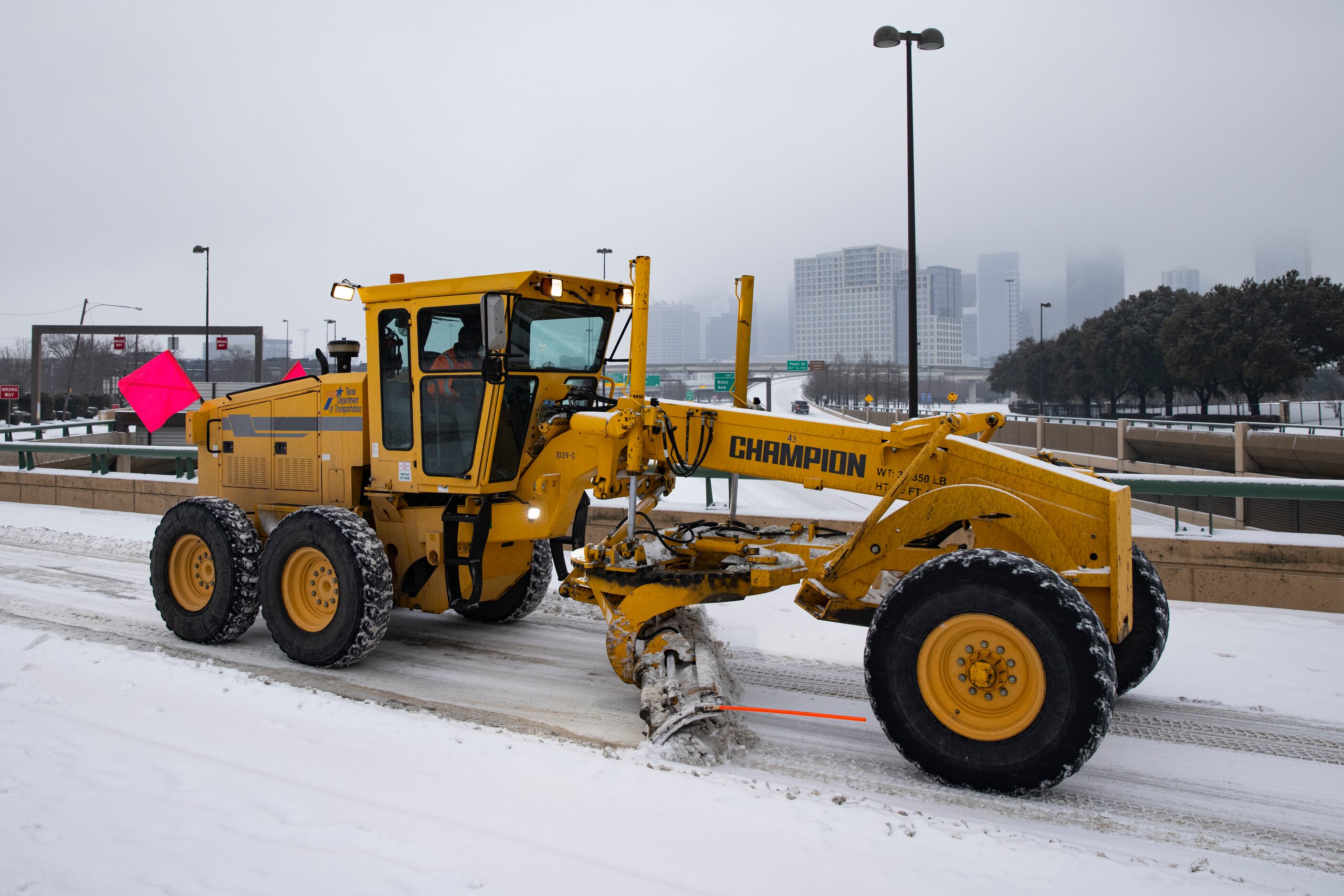 A TxDOT snowplow clears snow from N Hall St over North Central Expressway in Dallas on...