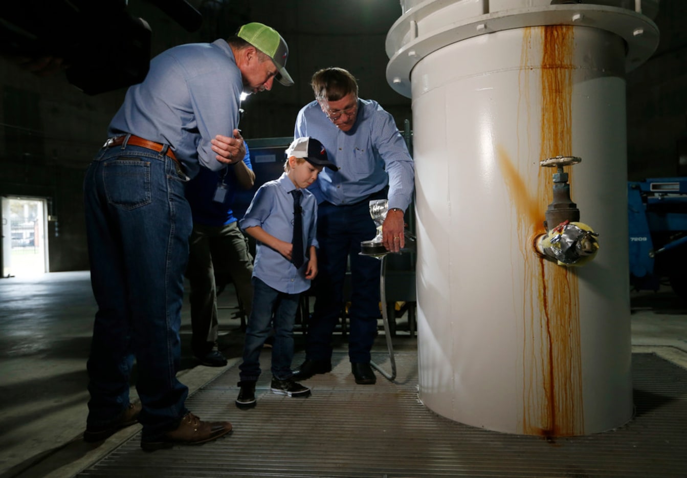 Jack Barfield (center), 5, listens to David Falls (right), public works operation manager...