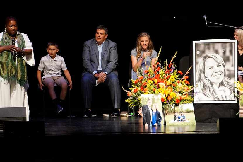 Cathryn McGill, standing, performs a song at a memorial service for Michael Riordan's wife...