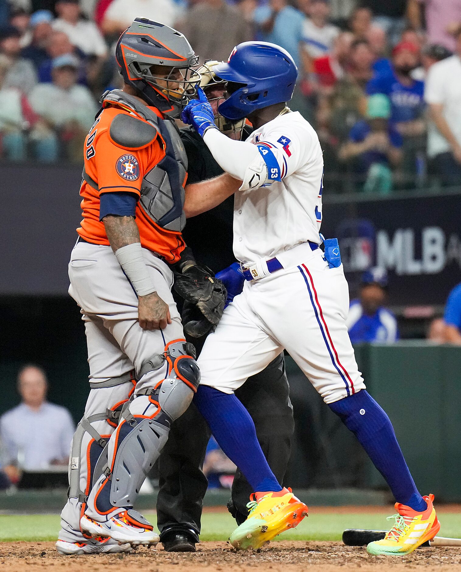 Umpire Marvin Hudson (51) tries to separate Texas Rangers right fielder Adolis Garcia (53)...