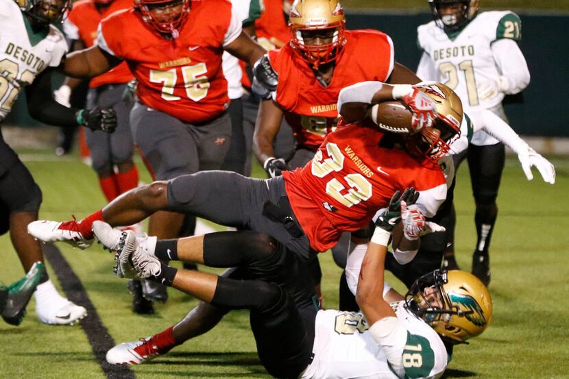 South Grand Prairie's Craig Woodson (33) jumps over Desoto's Austin Roland during the first...