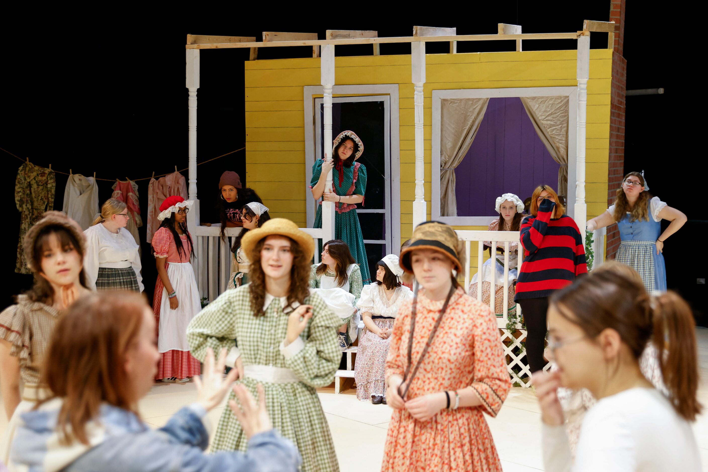 Choreographer Nicole Funderburg (front) instructs the dancers as other cast members remain...