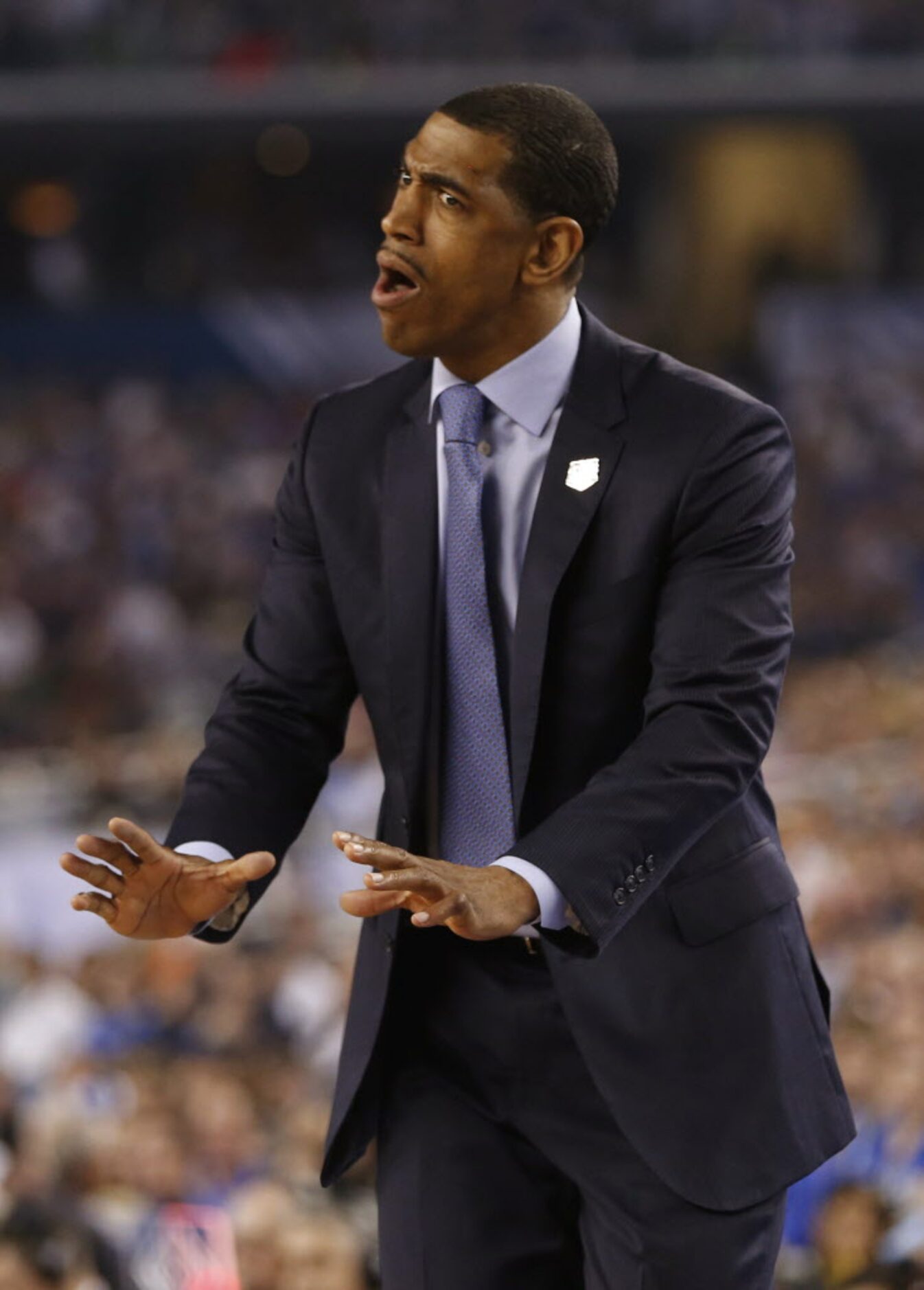 Connecticut Huskies head coach Kevin Ollie talks to his players in a game against the...